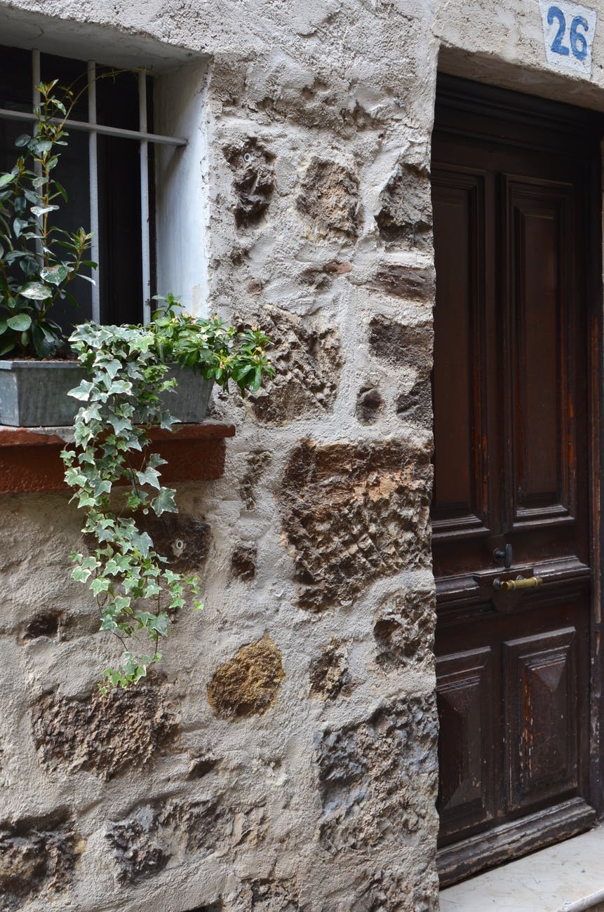building wall with potted plant on windowsill near door
